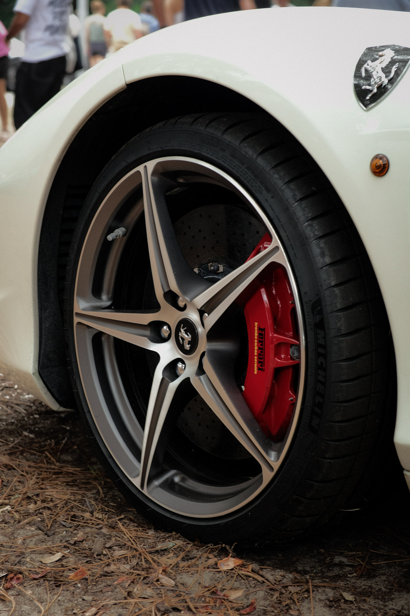 Roue avant, disque perforé et étrier rouge Ferrari d'une 458 Italia blanche
