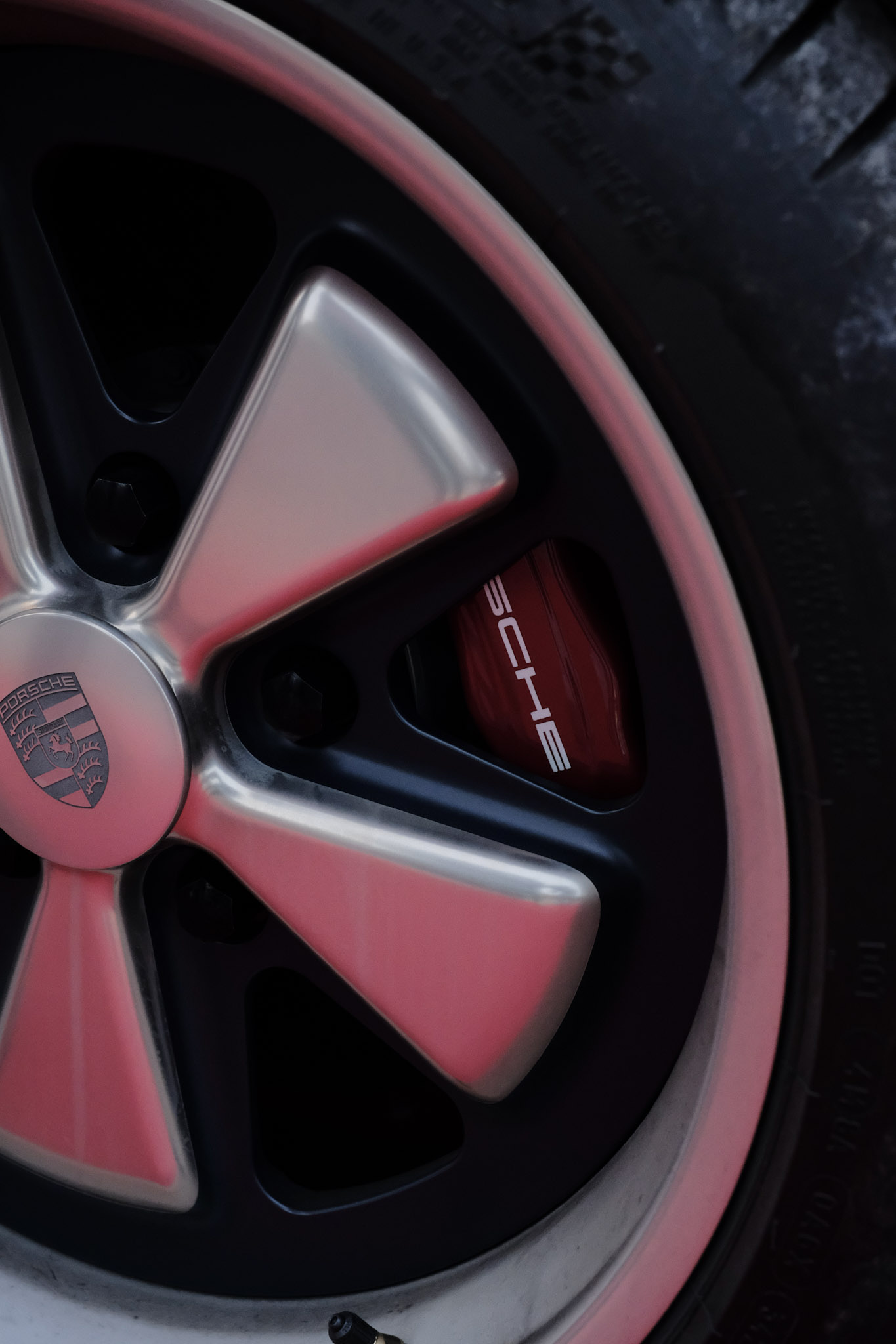 Jante style Fuchs Singer 5 branches — faces polies sur fond anthracite, étrier Porsche rouge